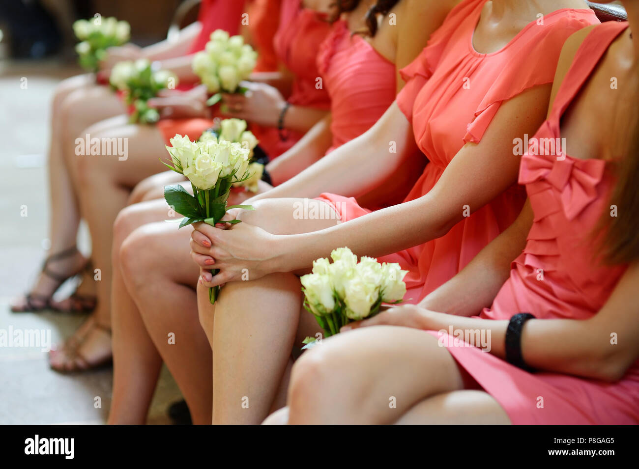 Row of bridesmaids with bouquets at wedding ceremony Stock Photo