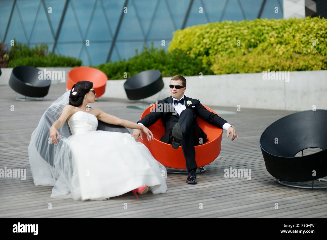 Happy bride and groom sitting in fancy chairs Stock Photo - Alamy