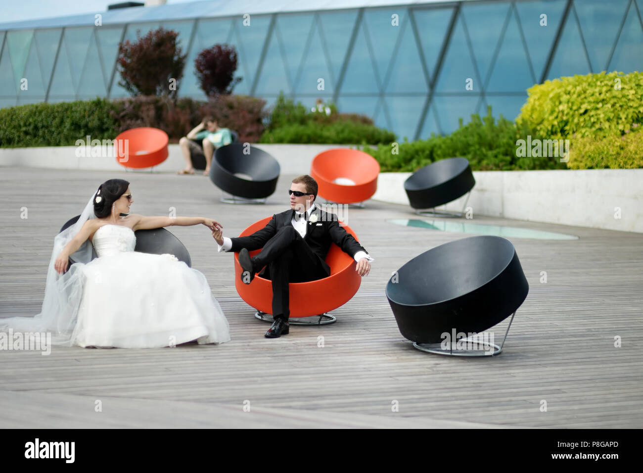 Happy bride and groom sitting in fancy chairs Stock Photo - Alamy