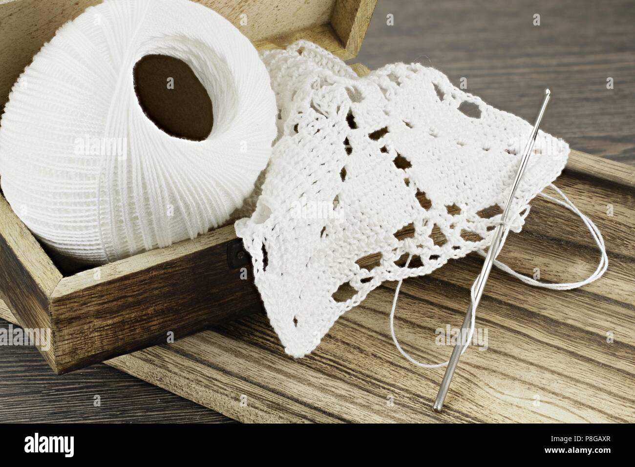 Handmade crochet doily and white yarn Stock Photo