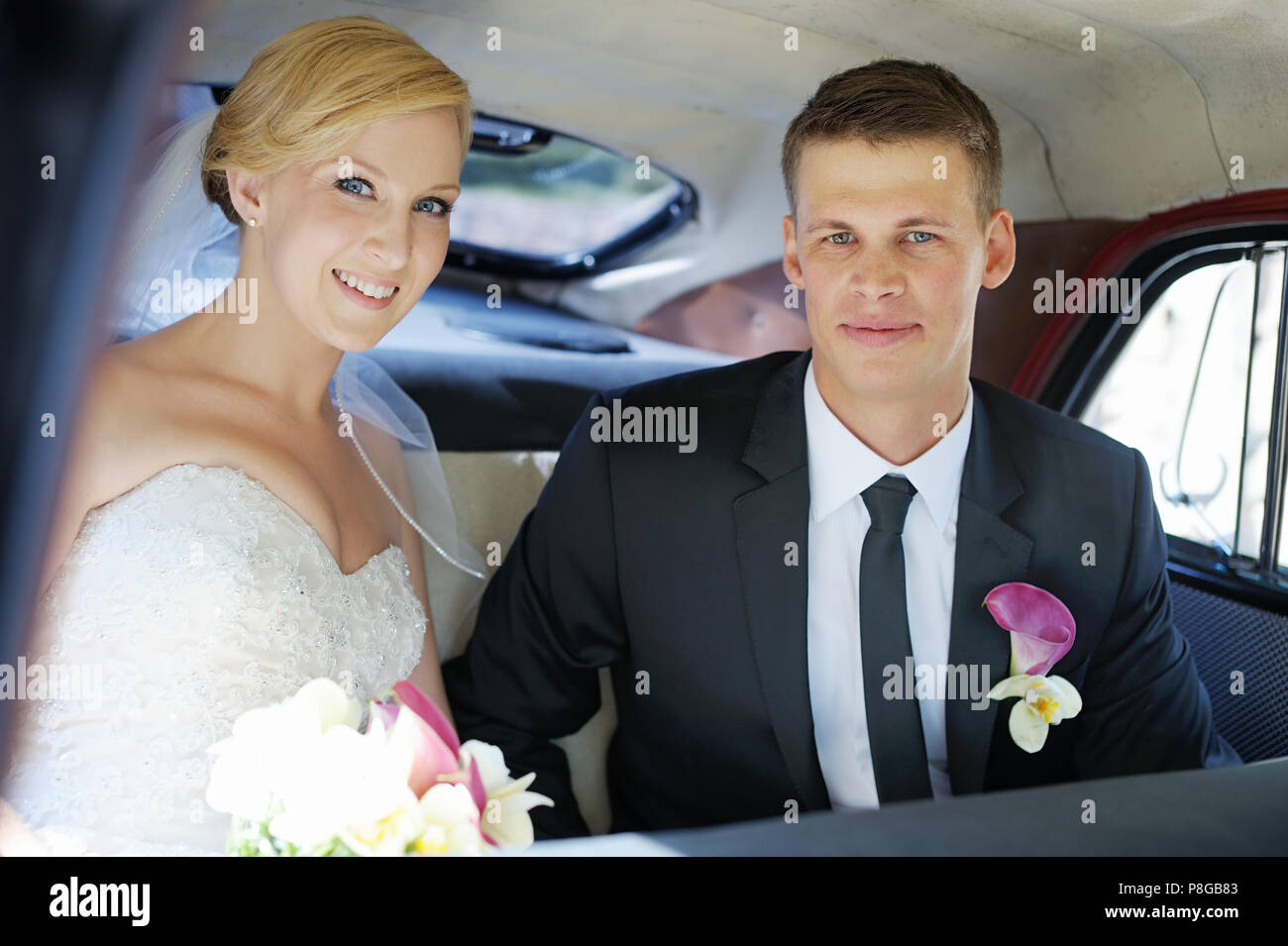 Bride and groom sitting in a vintage car Stock Photo - Alamy