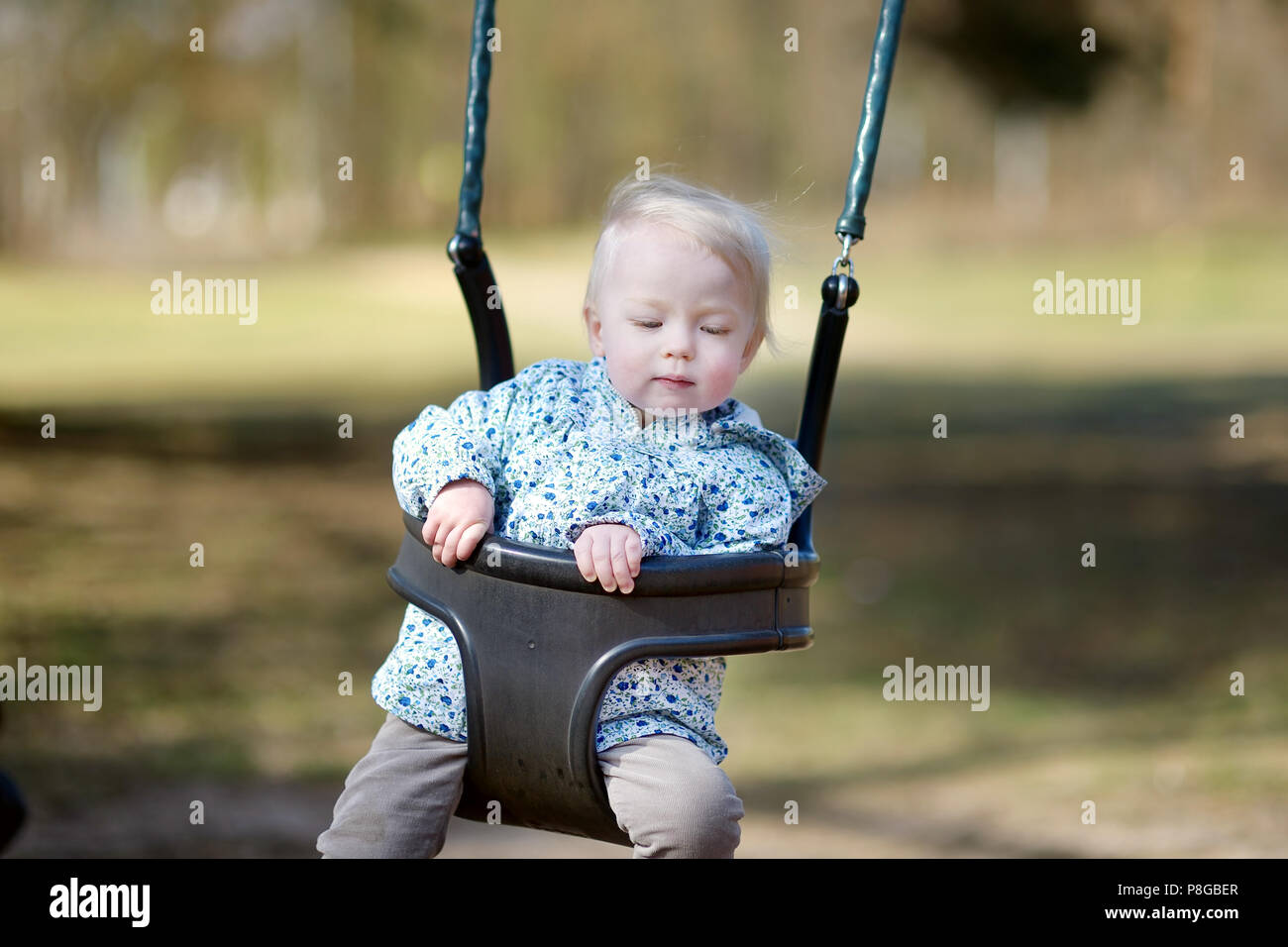 Swinging toddler girl having fun Stock Photo