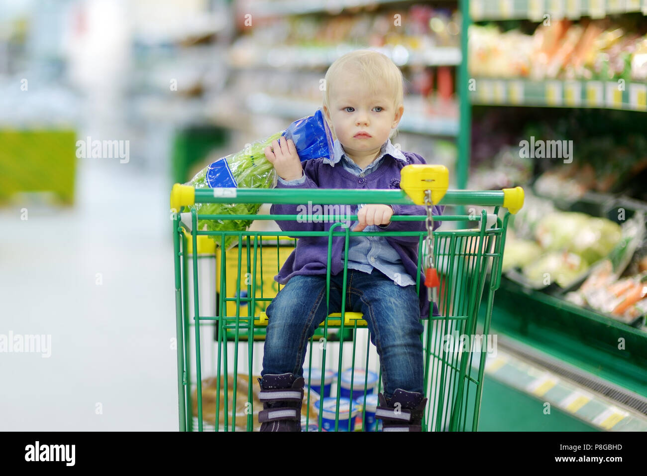 Adorable toddler girl sitting in shopping cart Stock Photo - Alamy