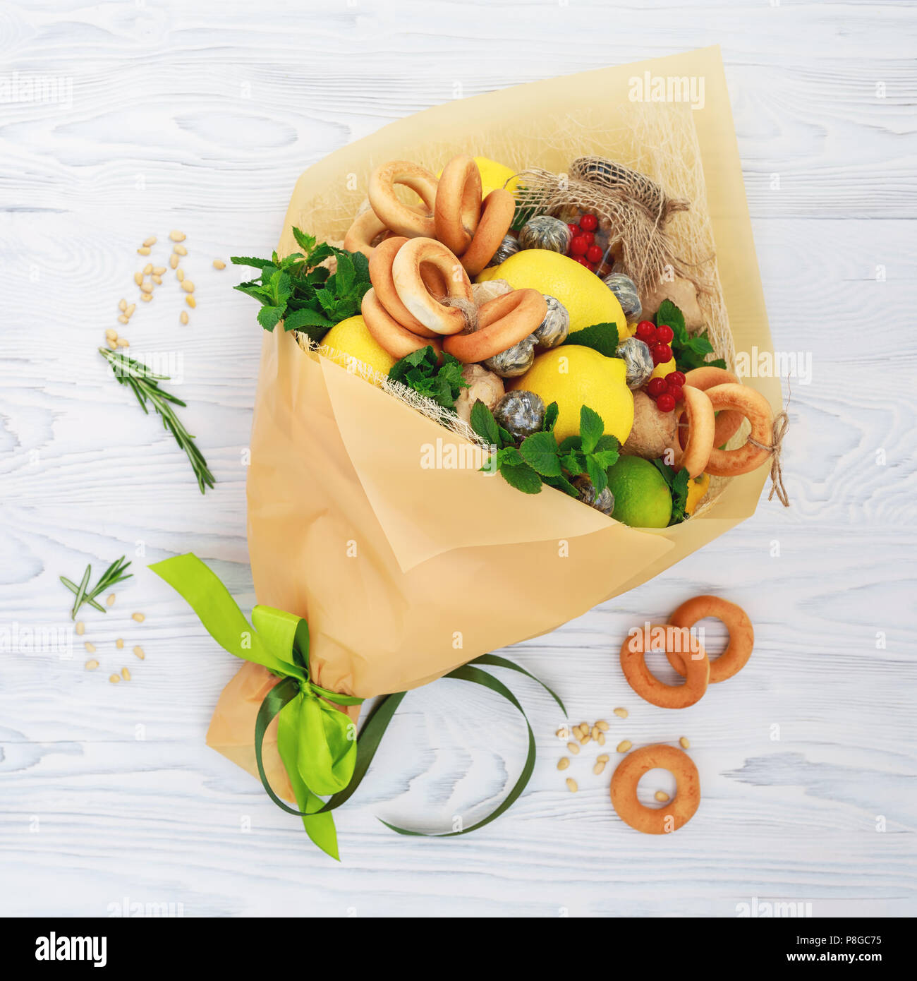 Bouquet consisting of honey, a bunch of bagels, mint leaves, lemons, lime, ginger and red currant on the white Stock Photo