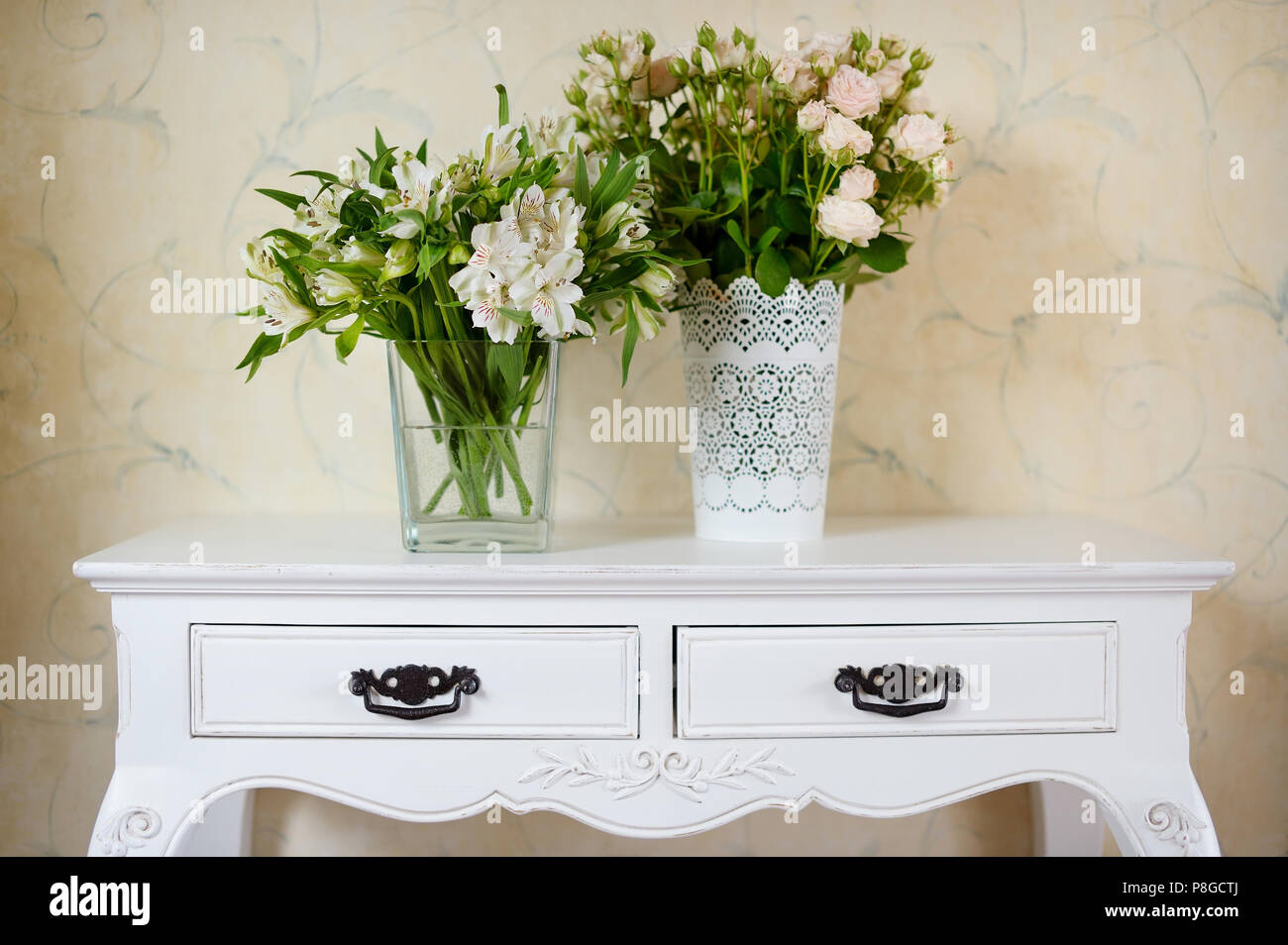 White vase full of white flowers on a counter Stock Photo