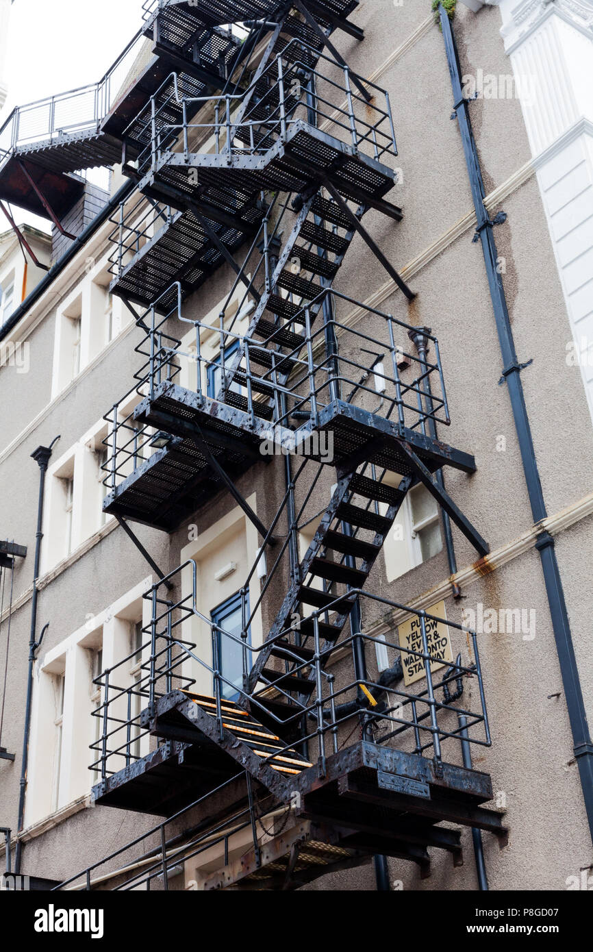 Metal fire escape stairs. Fire escape stairs behind a building. Stairs