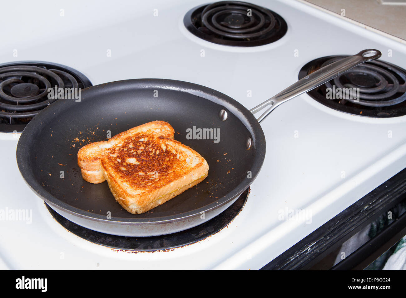 Grilled cheese up a worn out stove with a worn out nonstick pan. Single