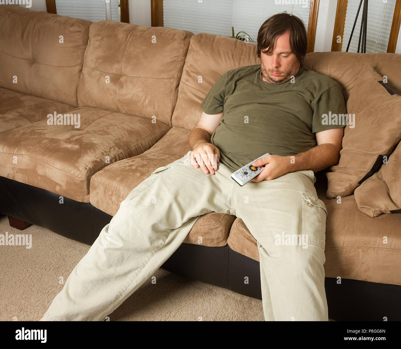 Obese Guy Sitting On The Couch With His Head Dropped As He Is Asleep obese-guy-sitting-on-the-couch-with-his-head-dropped-as-he-is-asleep