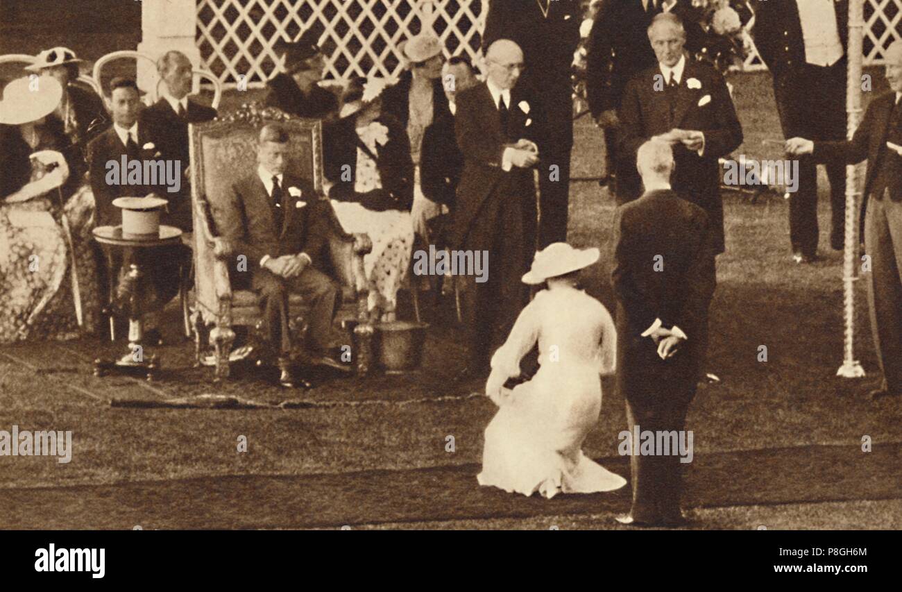 Debutantes, clad in their finery curtsey to King George V and Queen Mary  during a court presentation. Thus they are launched into  "Society". Date: 1928 - SuperStock