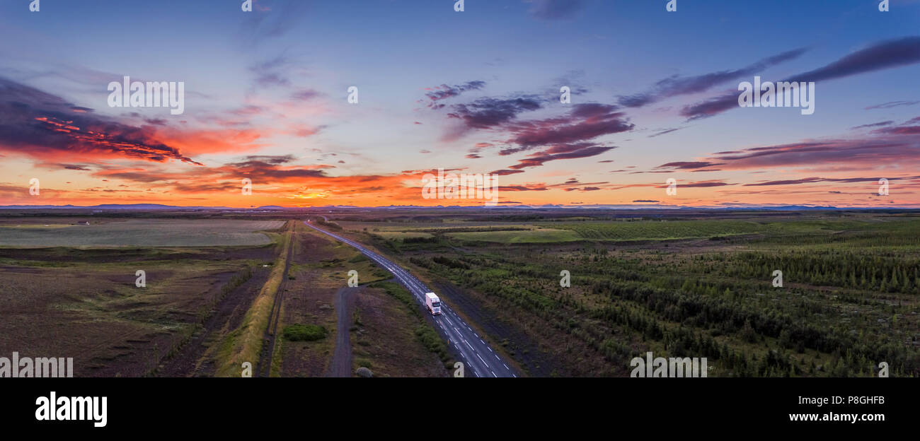 Truck driving on a countryroad at Sunset, Iceland Stock Photo