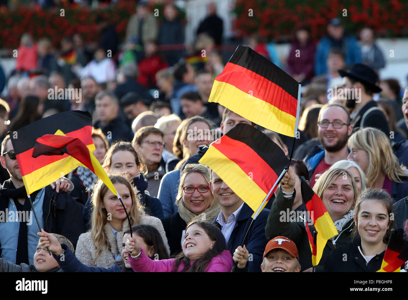 Hoppegarten, Germany, people wave national flags on the day of German unification Stock Photo