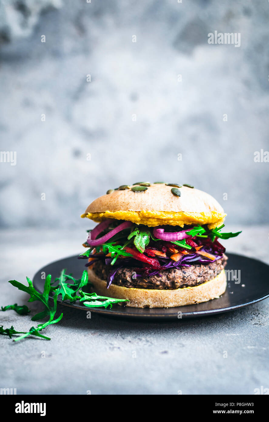 Black bean burgers with colourful toppings and hummus Stock Photo Alamy