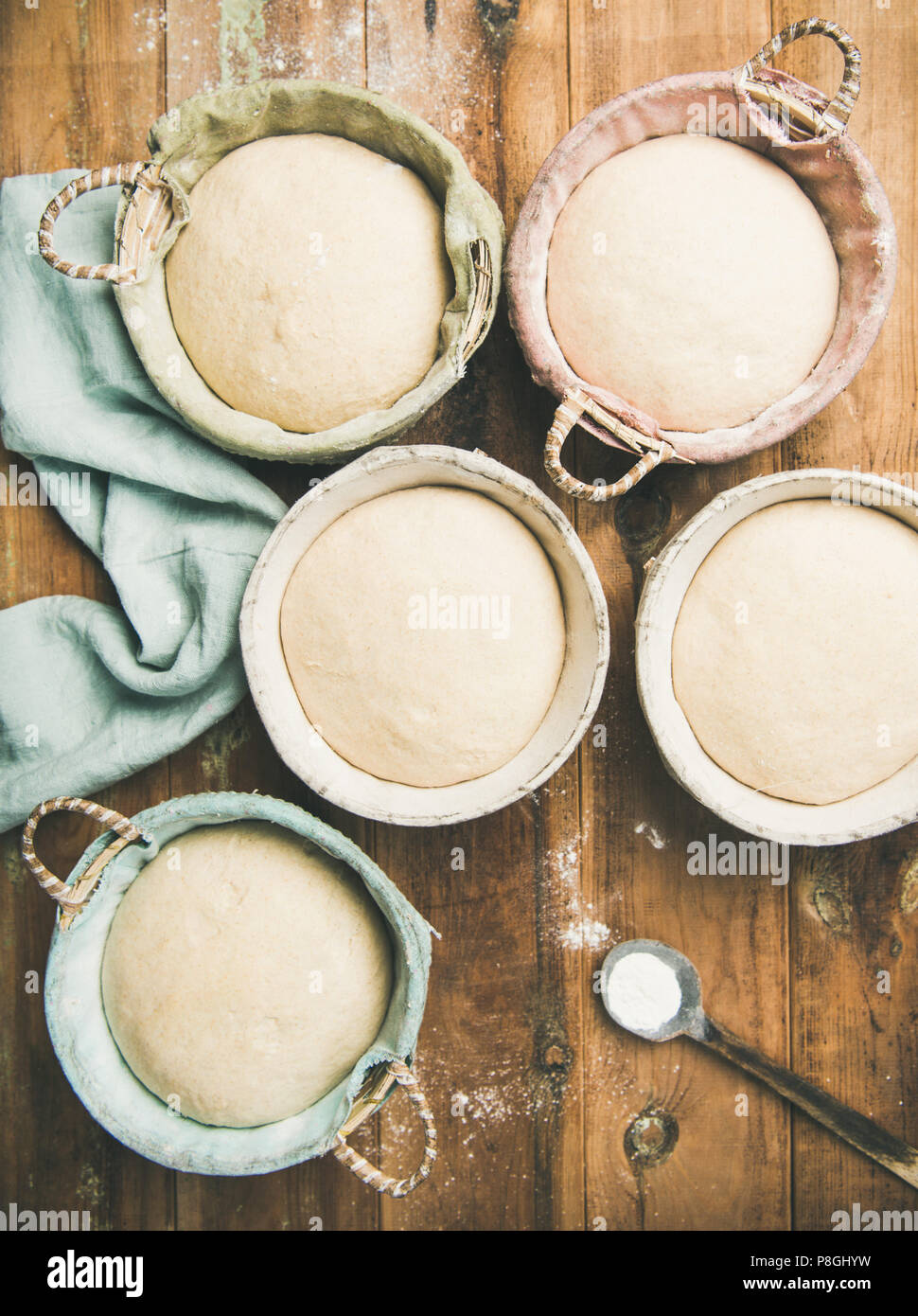 Sourdough for baking homemade wheat flour bread in baskets, over rustic