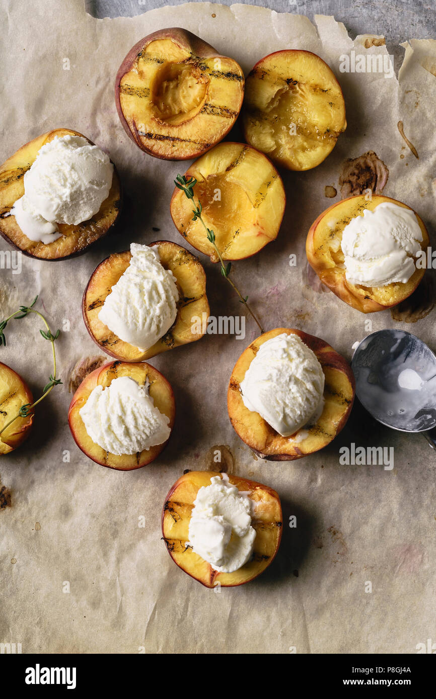 Melting vanilla ice cream served in hot grilled halved peaches and