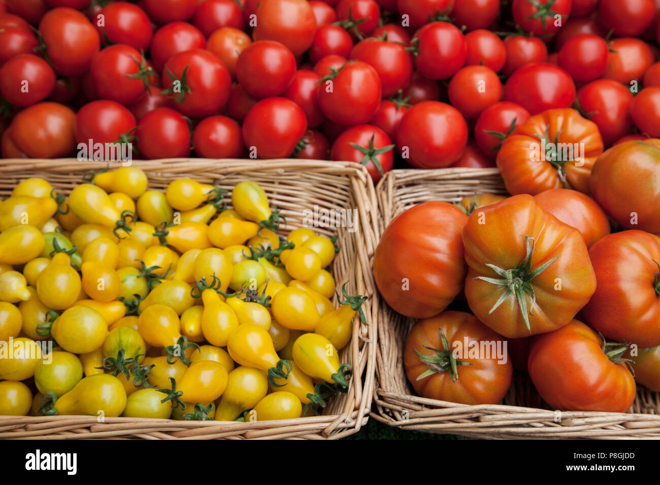 Mixed tomatoes in baskets on market stall Stock Photo - Alamy