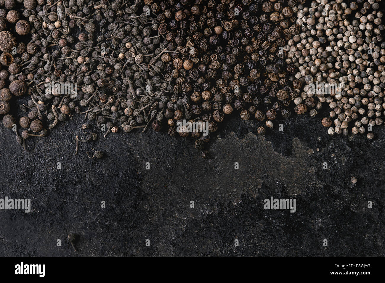 Variety of different black peppers allspice, pimento, monks pepper