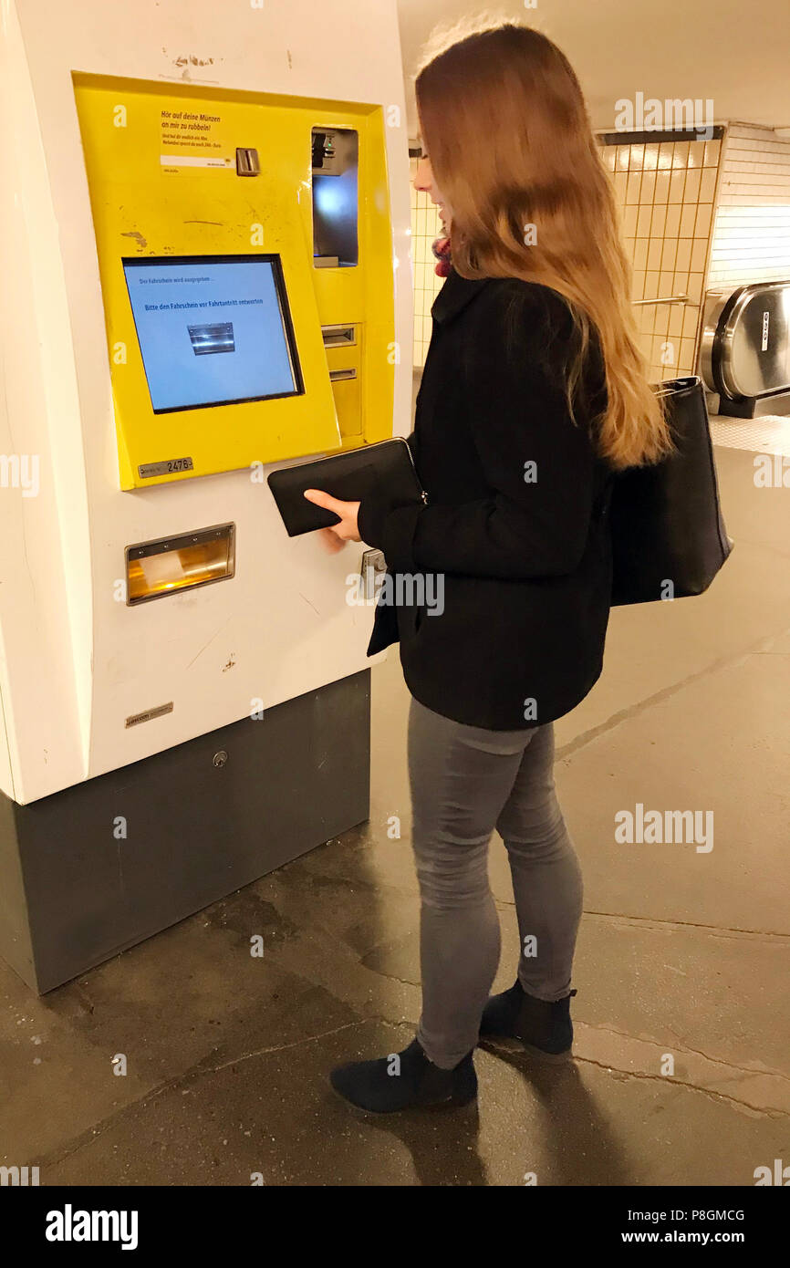 Berlin, Germany, young woman buys a ticket at a vending machine of the BVG Stock Photo