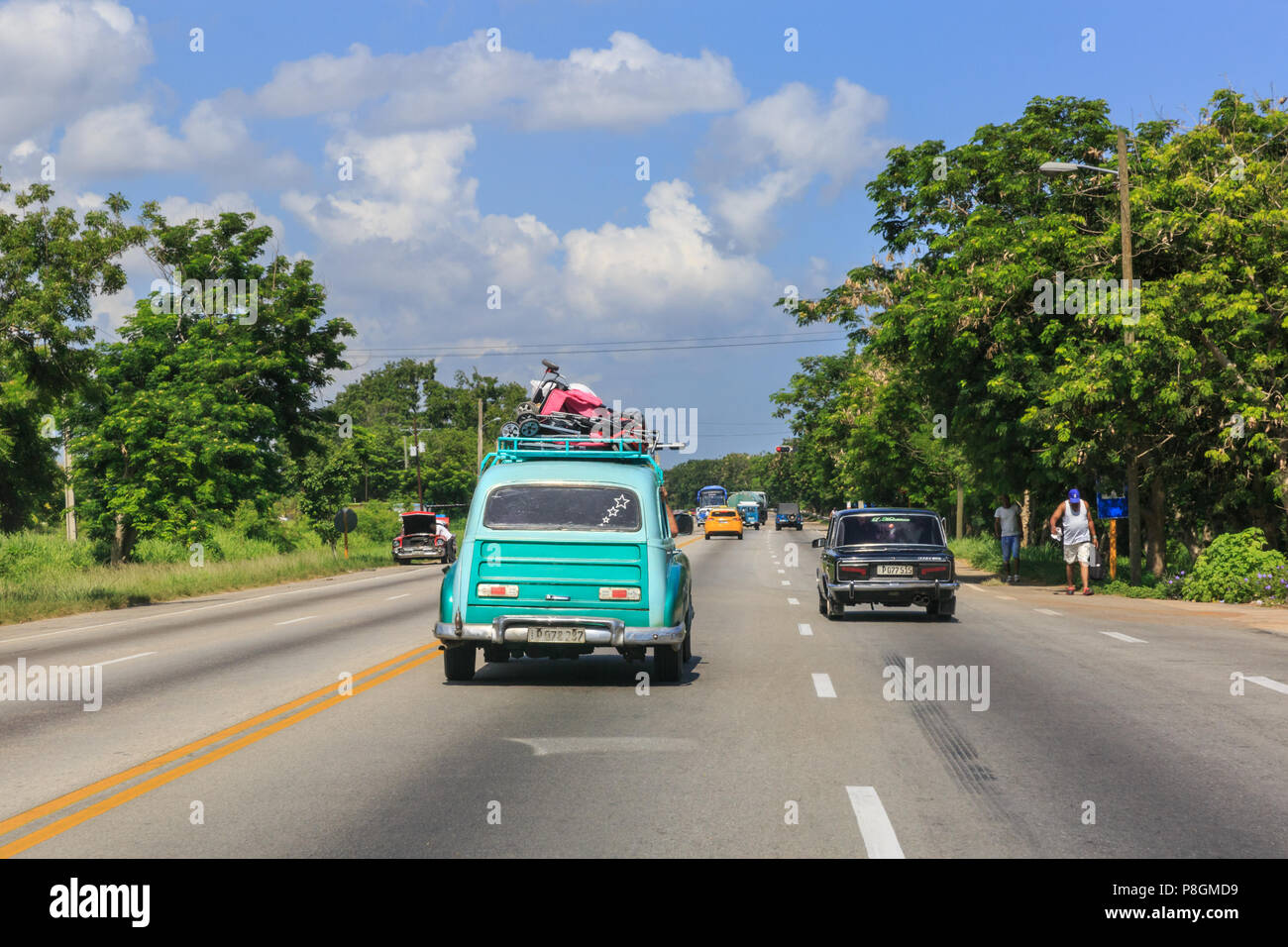 Old car, heavily packed on the roof rack, travelling on a motorway hear Havana, Cuba Stock Photo