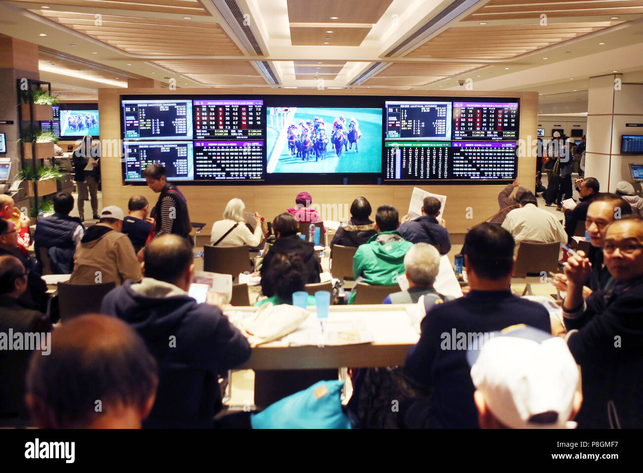 Hong Kong, China, people in a betting hall of the racecourse Sha Tin Stock Photo