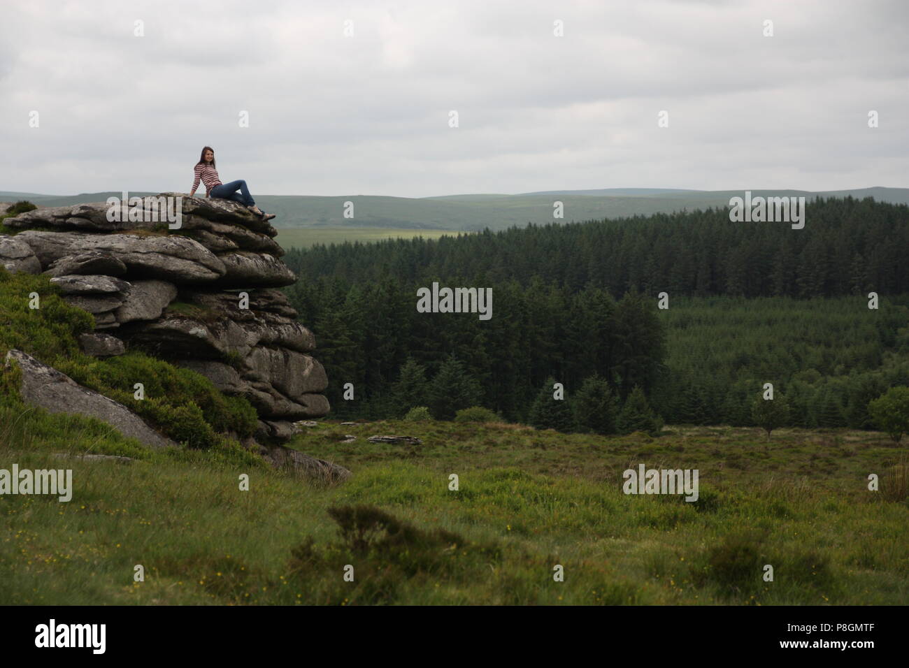 Beautiful woman on granite tor on dartmoor in the great outdoors Stock Photo