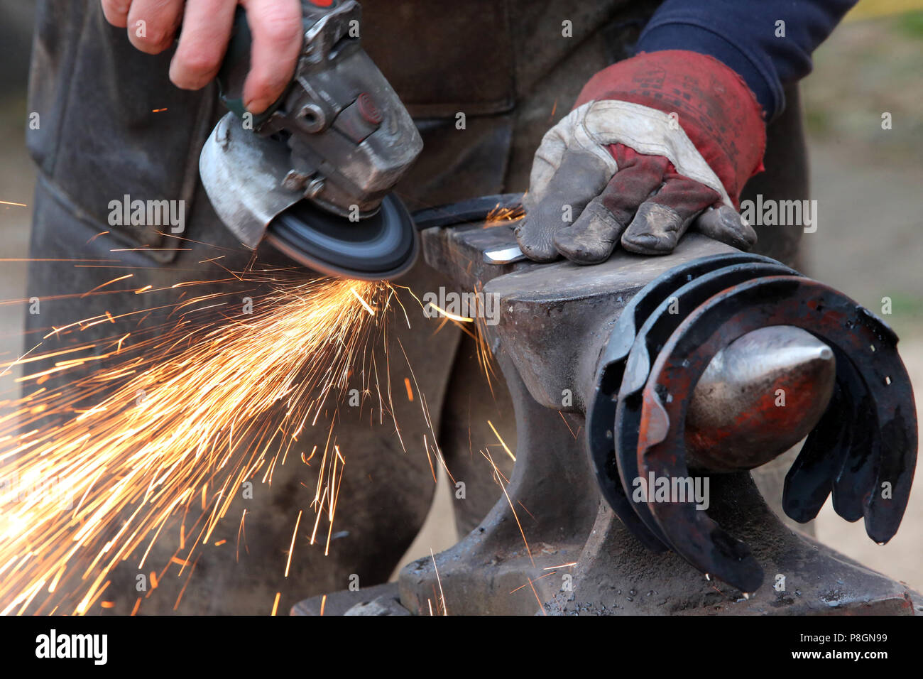 Neustadt (Dosse), horseshoe is worked with an eccentric sander Stock Photo