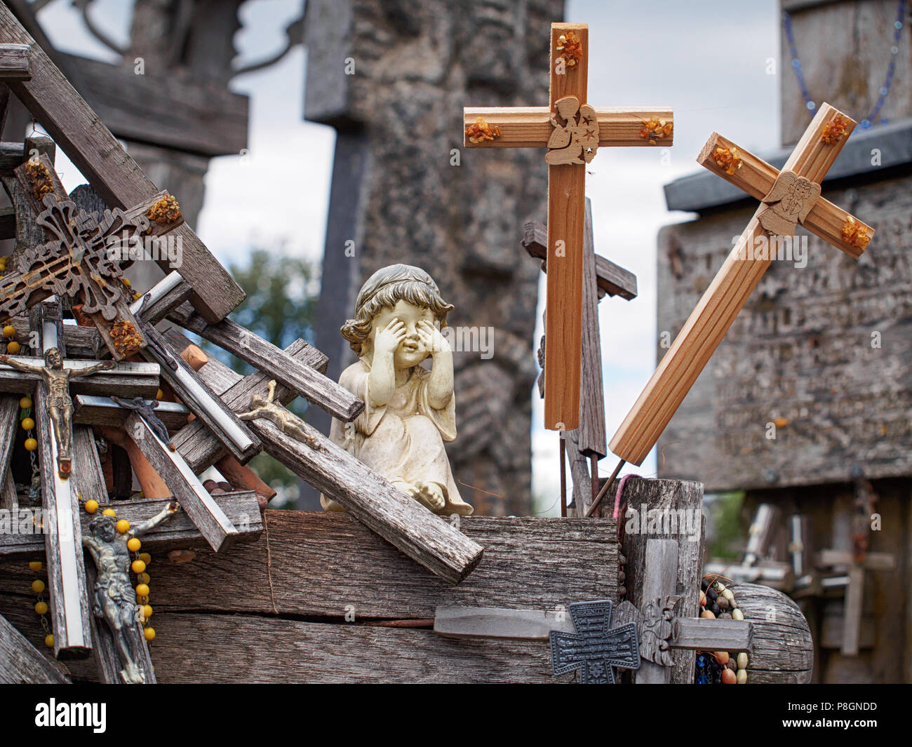 Statuette of a little girl surrounded by wooden crosses Stock Photo