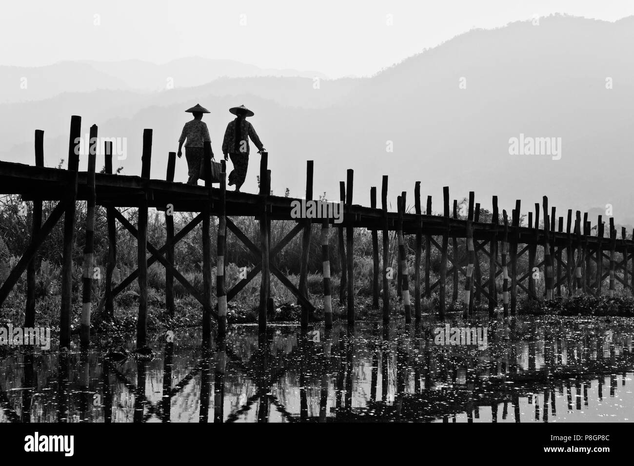 BURMESE use the raised walkway near the village of MAING THAUK on the way to the weekly market - INLE LAKE, MYANMAR Stock Photo