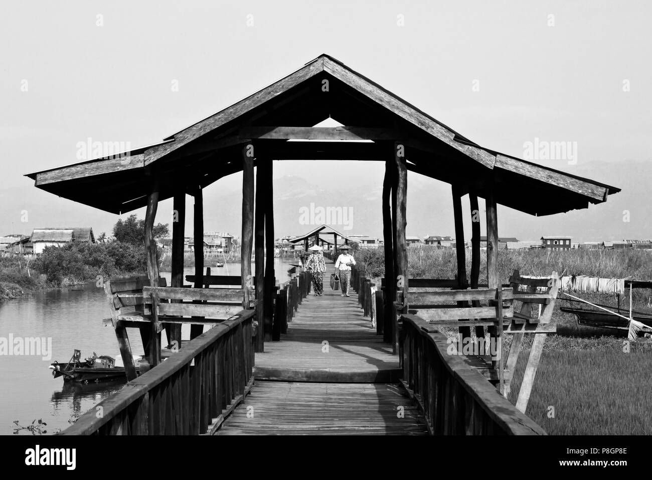 BURMESE use the raised walkway near the village of MAING THAUK on the way to the weekly market - INLE LAKE, MYANMAR Stock Photo