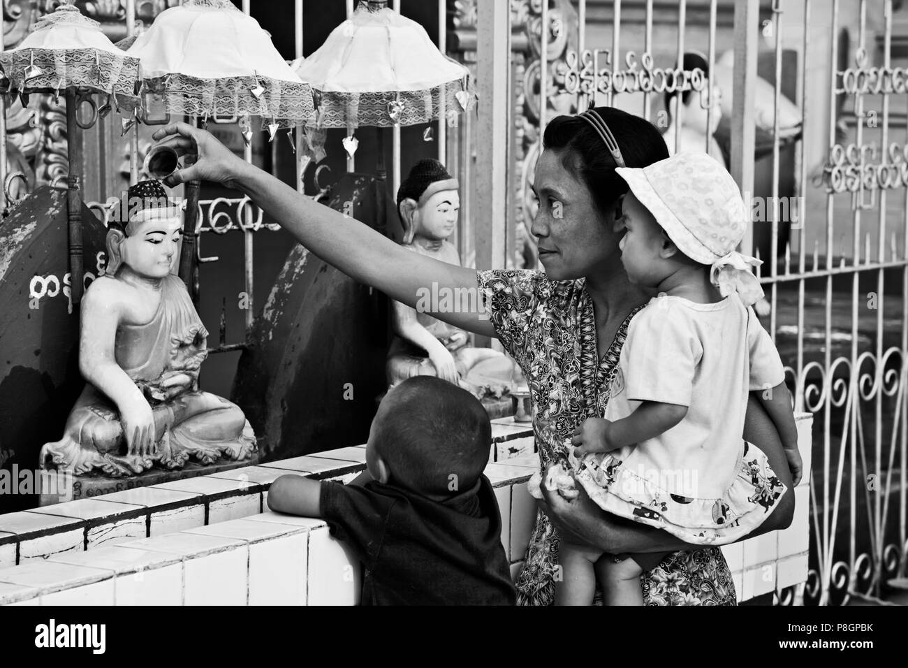 Making water offerings at a BUDDHIST TEMPLE in the town of PYIN U LWIN also known as MAYMYO - MYANMAR Stock Photo