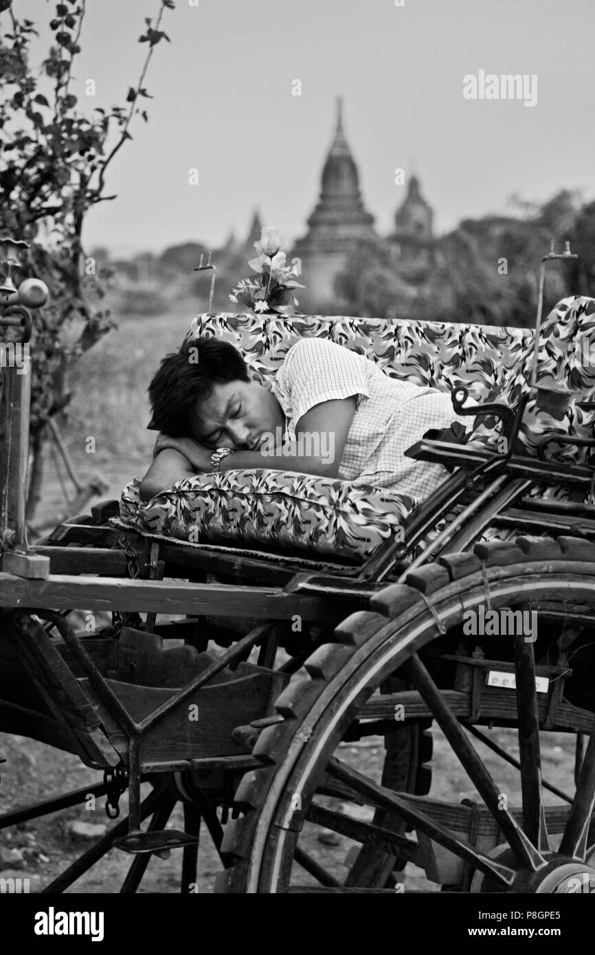 A cart driver takes a rest during a dawn mission - BAGAN, MYANMAR Stock ...