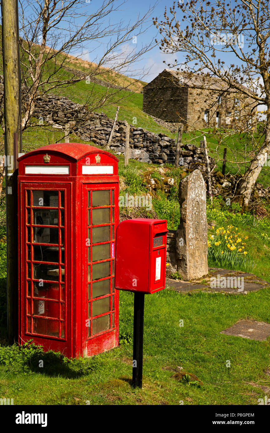 UK, England, Yorkshire, Swaledale, Angram, red phone and post boxes beside carved village name stone Stock Photo