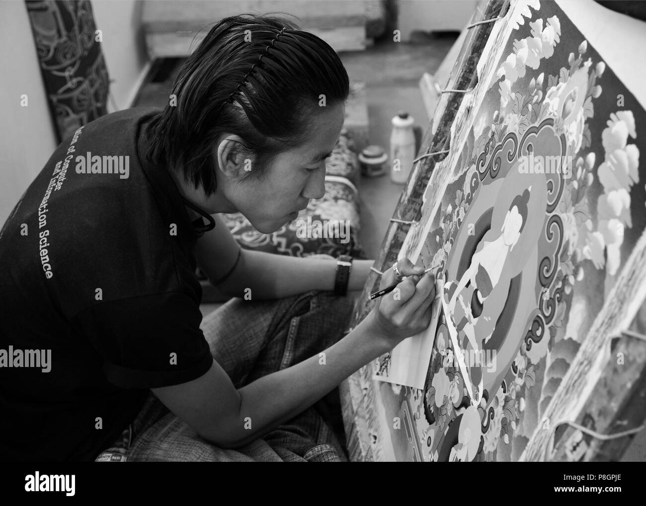 A THANKA PAINTER learns his craft at the NORBULINGKA INSTITUTE, a TIBETAN BUDDHIST CULTURAL CENTER - DHARAMSALA, INDIA Stock Photo