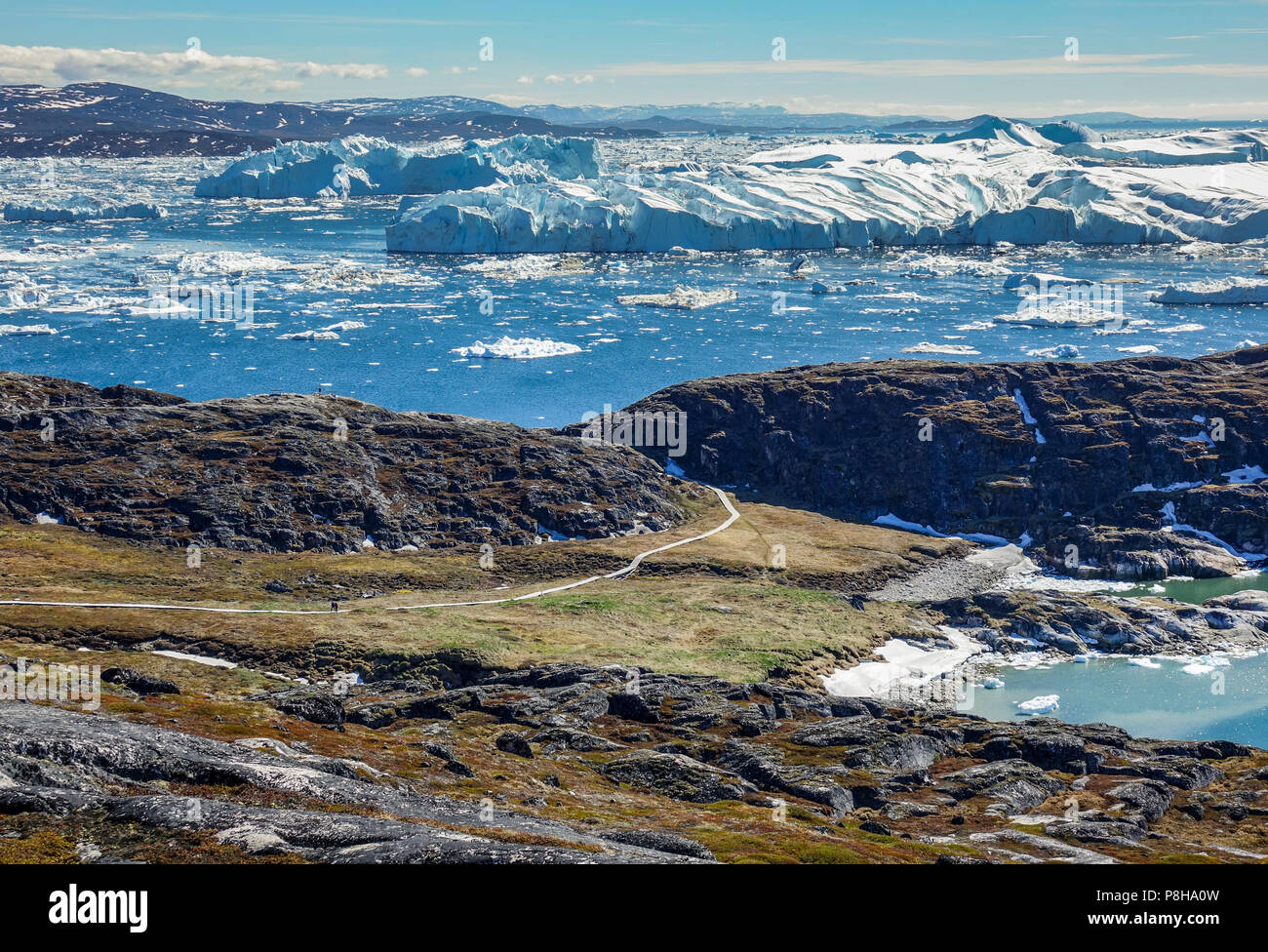 24.06.2018, Gronland, Denmark: Huge icebergs drifting in the sea in front of the coastal town of Ilulissat in western Greenland. The city is located on the Ilulissat Icefjord, which is known for its particularly large icebergs in Disko Bay. Photo: Patrick Pleul/dpa-Zentralbild/ZB | usage worldwide Stock Photo