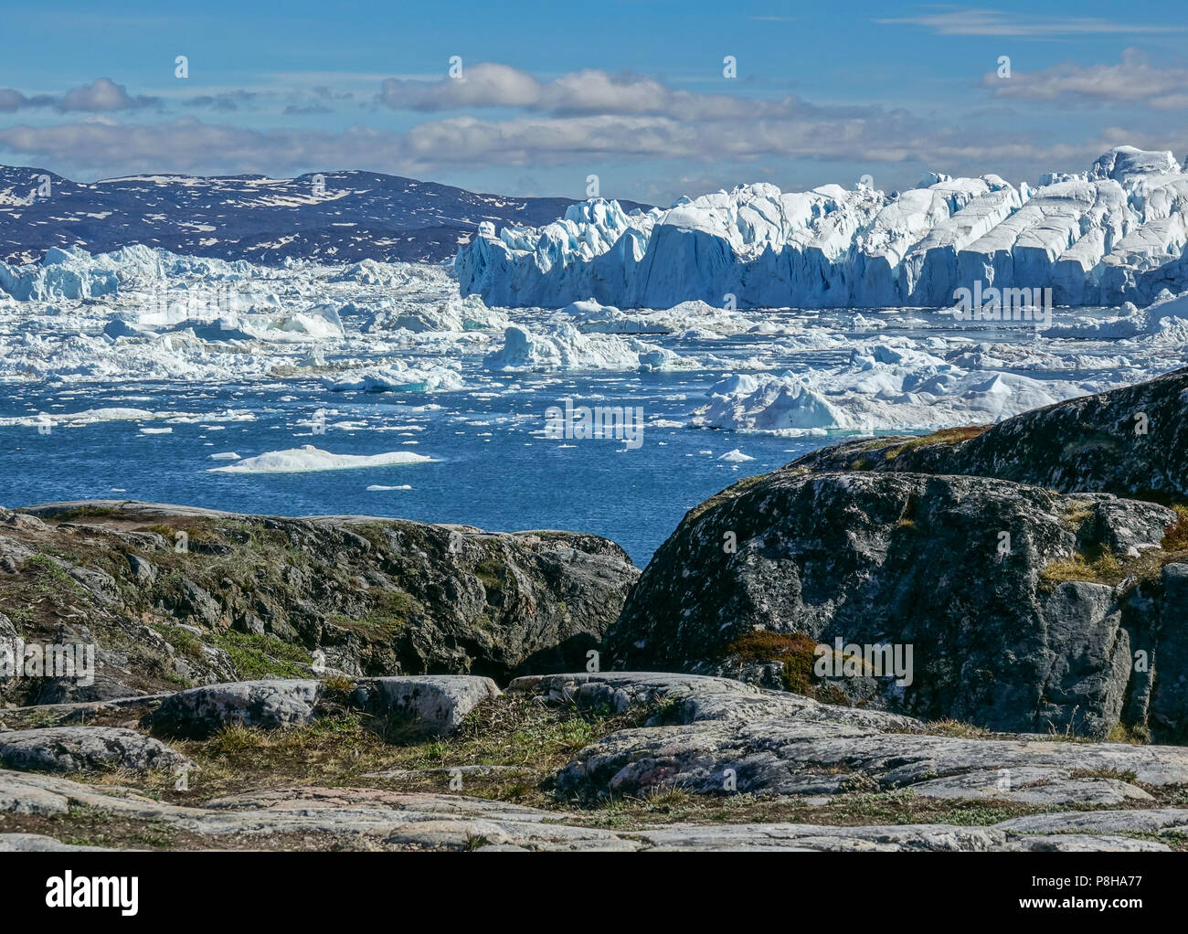 22.06.2018, Gronland, Denmark: Huge icebergs floating in the sea in front of the coastal town of Ilulissat in western Greenland. The city is located on the Ilulissat Icefjord, which is known for its particularly large icebergs in Disko Bay. Photo: Patrick Pleul/dpa-Zentralbild/ZB | usage worldwide Stock Photo