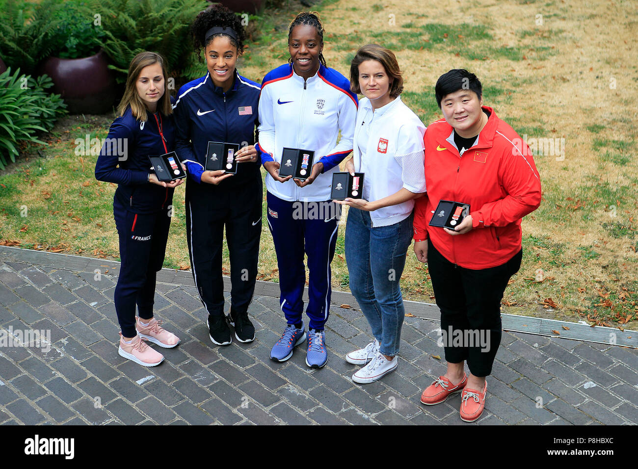 London, UK. 11th July, 2018. Lorraine Ugen of Great Britain (c), Queen Harrison of the USA (2L), Ninon Guillon-Romarin of France (1L), Anna Jagaciak-Michalska of Poland (1R) and Gong Lijiao of China (2R) pose with their medals.  all the athletics world cup team captains, all Women, today are presented with unique Platinum captain's medals marking 100 years since first British women secured the right to vote. Athletics World Cup media day at the Terrace Gallery, Museum of London in London on Thursday 12th July 2018. Credit: Andrew Orchard sports photography/Alamy Live News Stock Photo