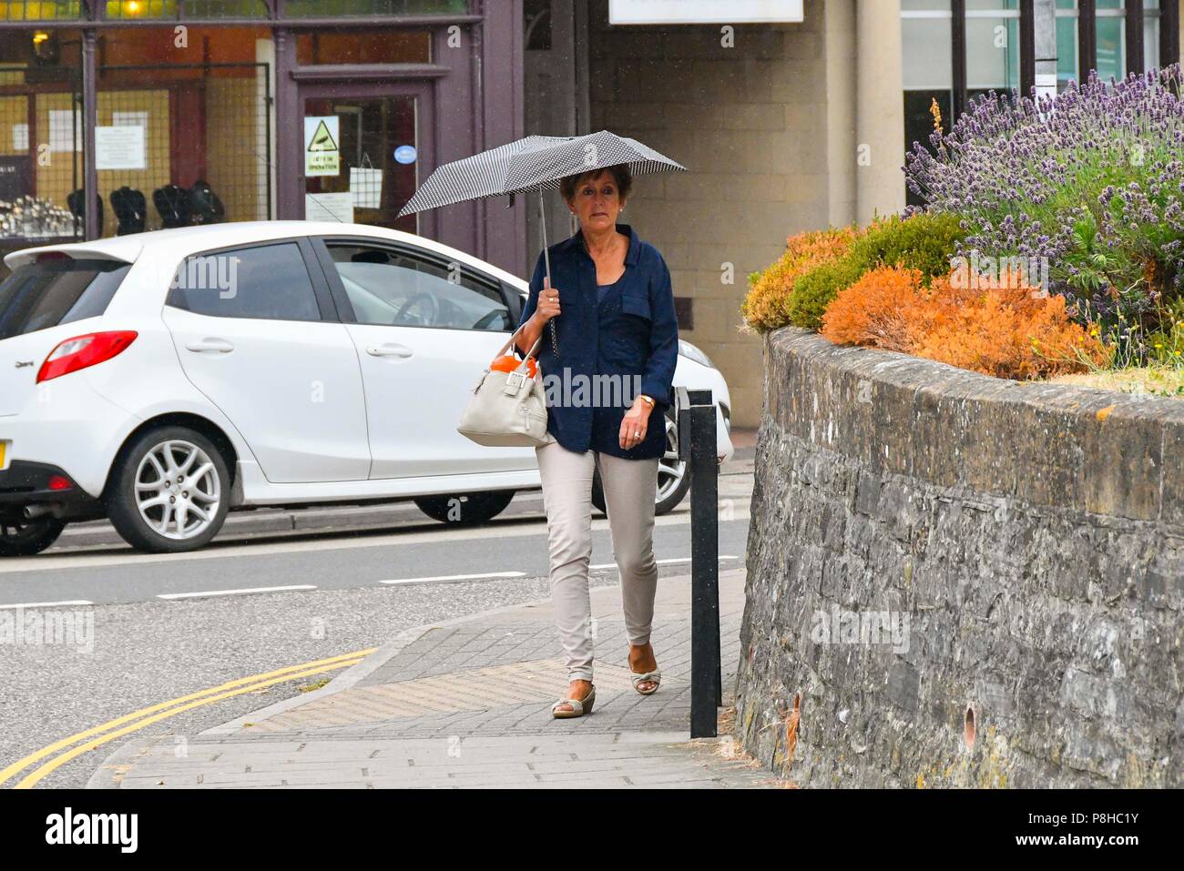 Axminster, Devon, UK. 12th July 2018. UK Weather. Shoppers in the town