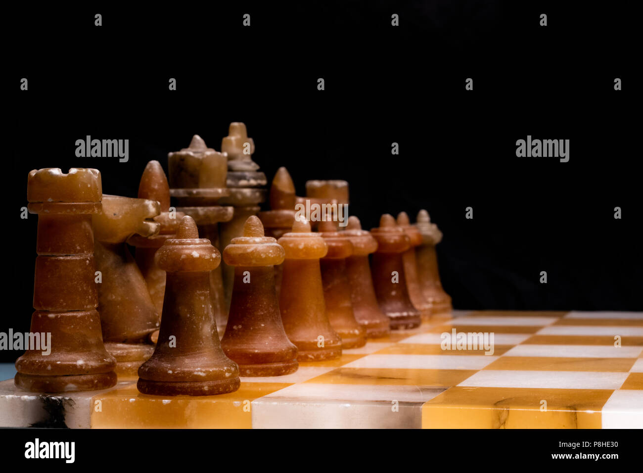 Side view of a stone chessboard focussing on the black pieces Stock ...