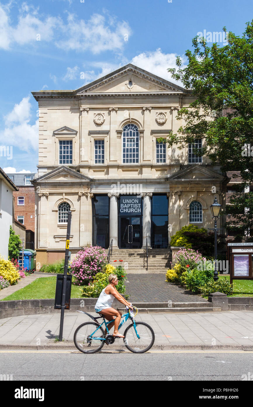 High Wycombe, UK - 3rd Lune 2018: A woman cyclist rides past the Union Baptist Church. It holds 2 services each Sunday. Stock Photo