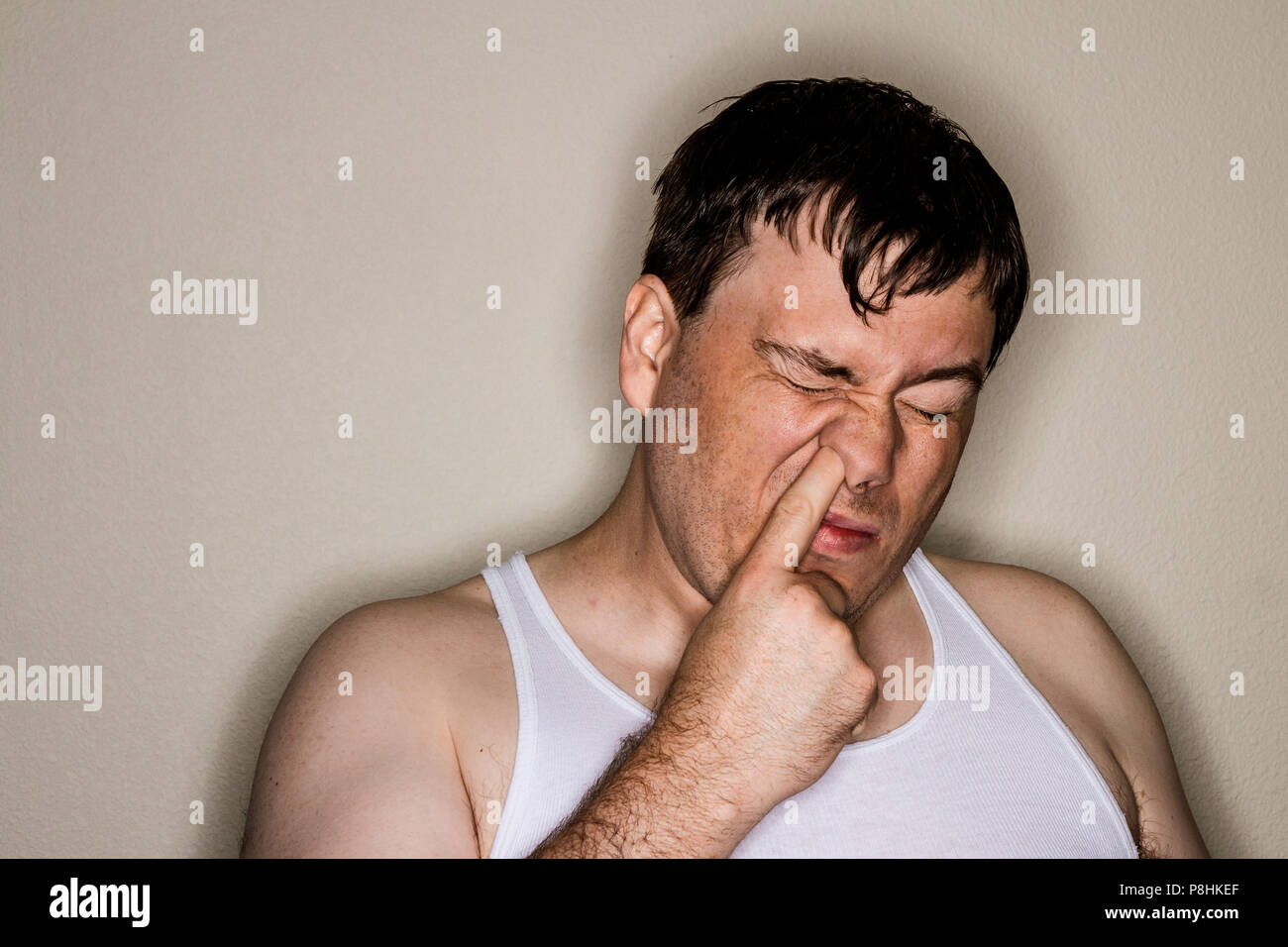 Guy digging deep up his nose trying to pick a booger out Stock Photo