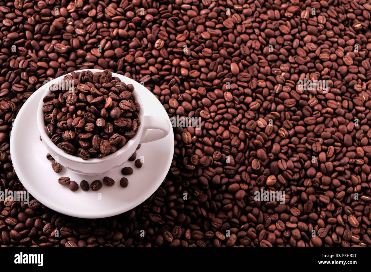 White coffee cup filled with roasted beans Stock Photo