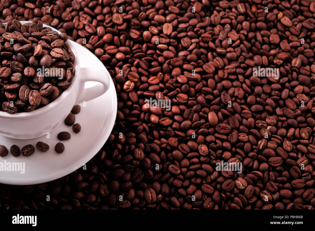 White coffee cup filled with roasted beans Stock Photo