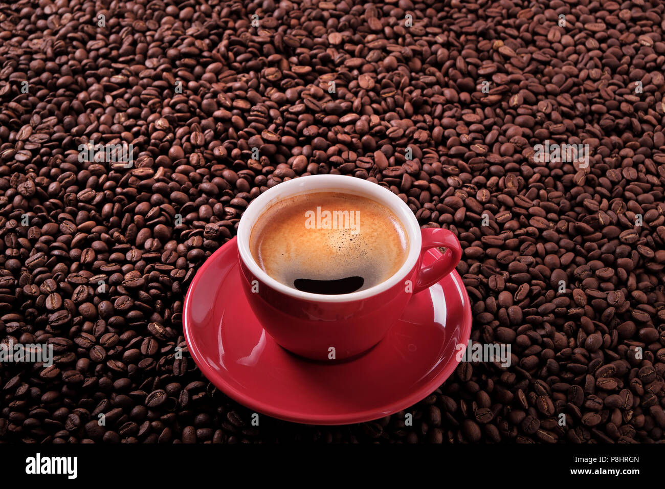 Red coffee cup with espresso and roasted beans background Stock Photo