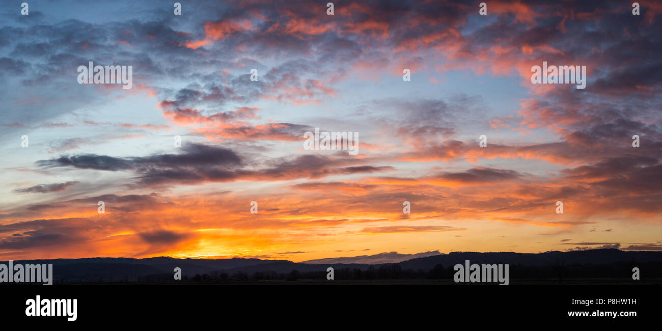 Natural Sunset Sunrise Over Field Or Meadow. Bright Dramatic Sky And Dark Ground. Countryside Landscape Under Scenic Colorful Sky At Sunset Dawn Sunri Stock Photo