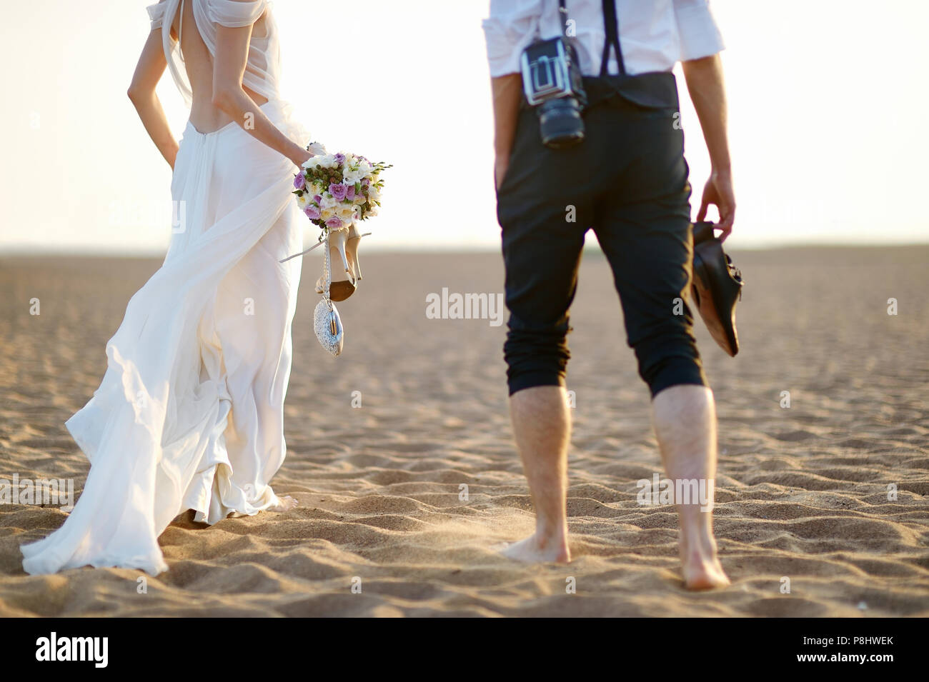 Happy bride and groom on a beautiful beach on sunset Stock Photo - Alamy