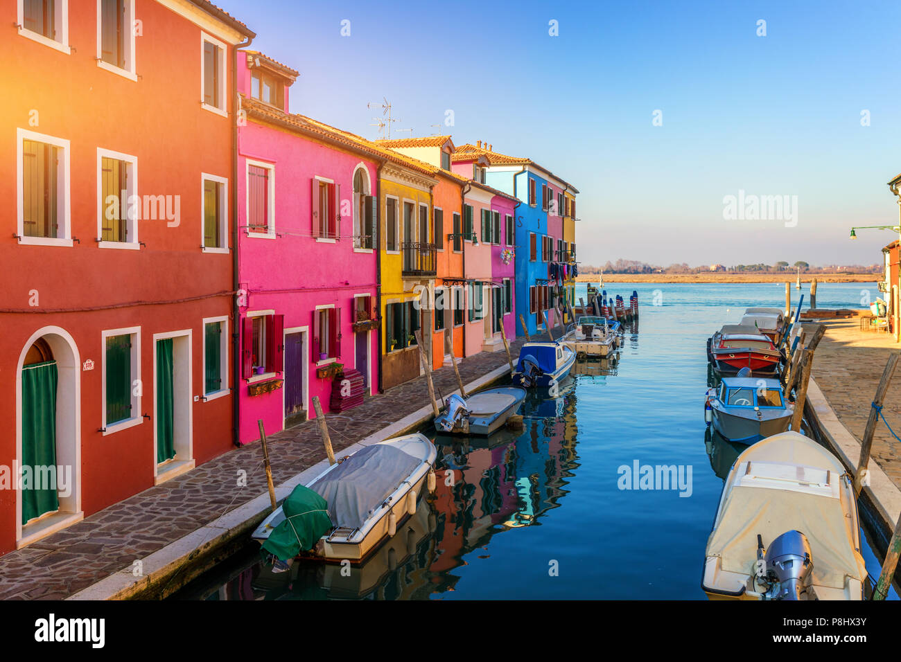 Street with colorful buildings in Burano island, Venice, Italy. Architecture and landmarks of Burano, Venice postcard. Scenic canal and colorful archi Stock Photo