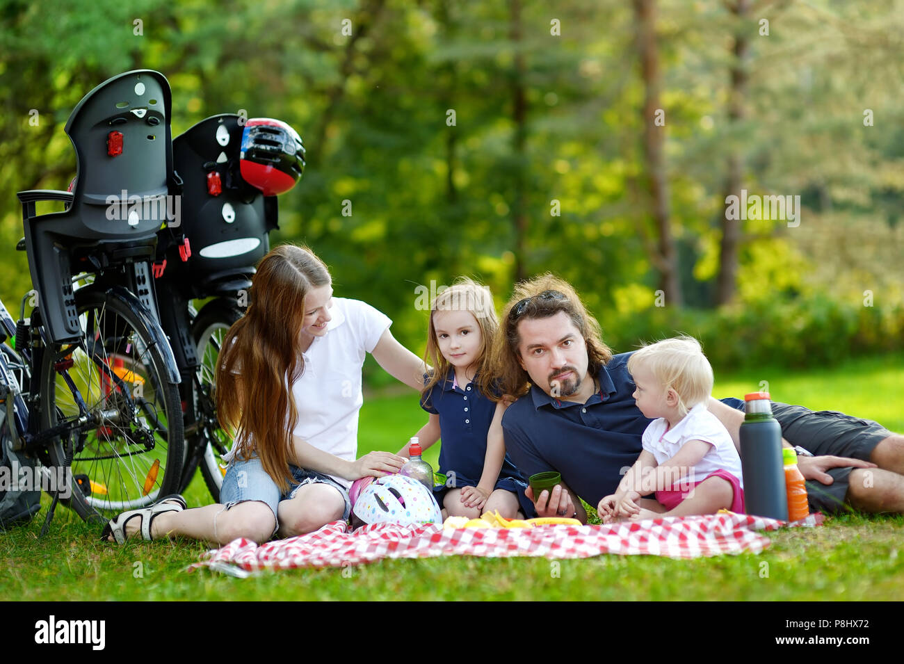 Happy family of four picnicking in the park Stock Photo - Alamy