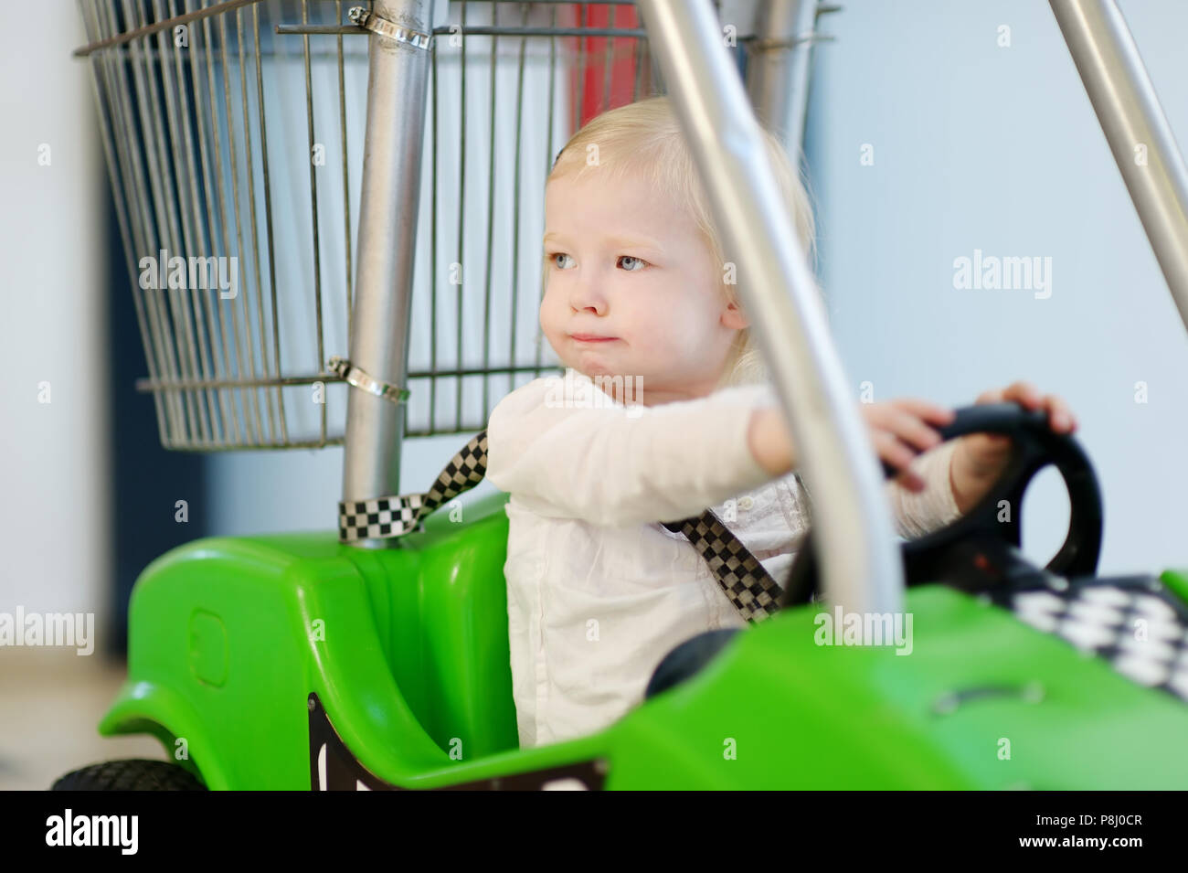 Adorable little girl sitting in shopping cart Stock Photo - Alamy
