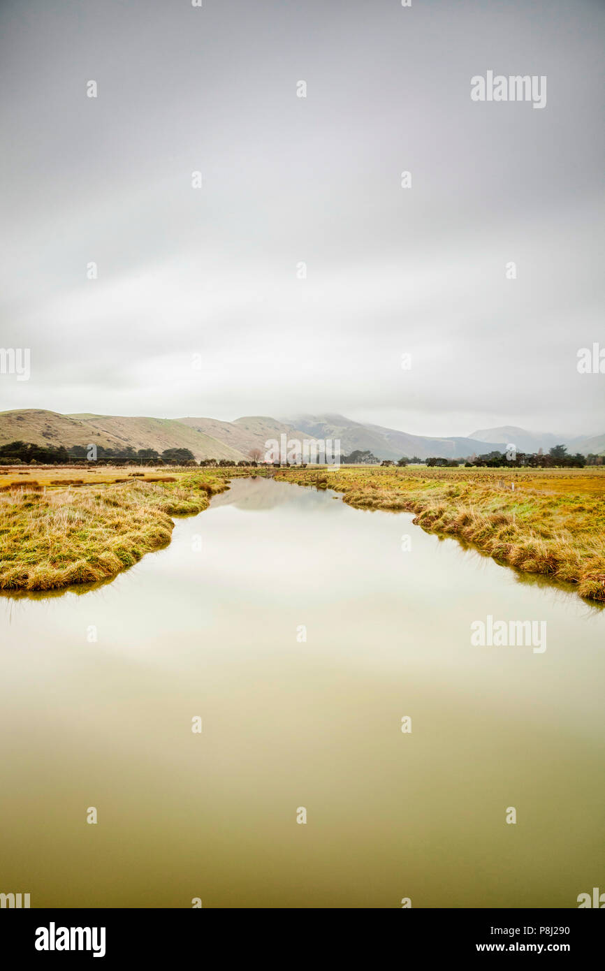 Smooth water under a moody sky. Stock Photo