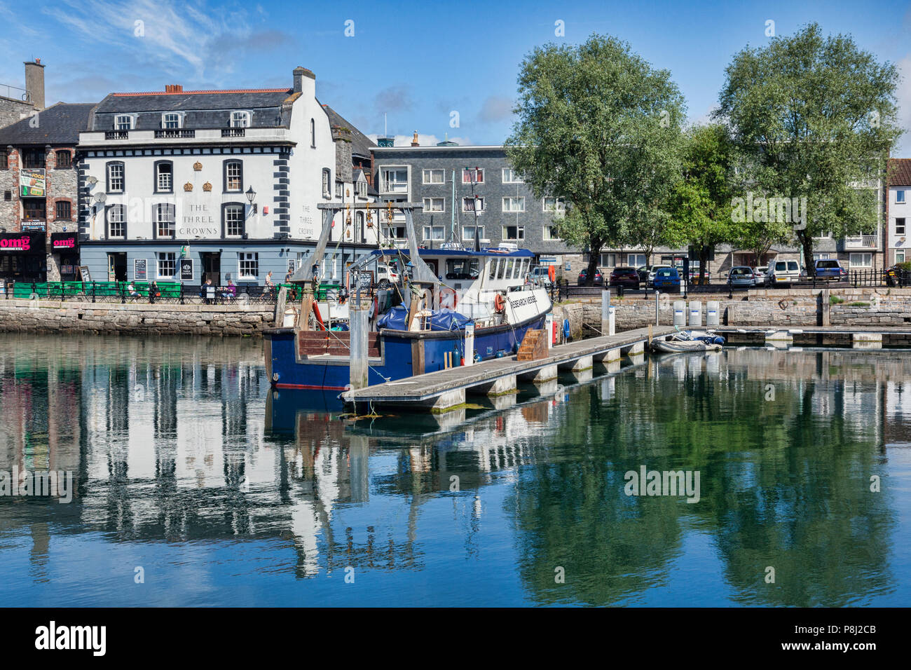 2 June 2018: Plymouth, Devon, UK - The Barbican with The Three Crowns public house reflecting in the water. Stock Photo