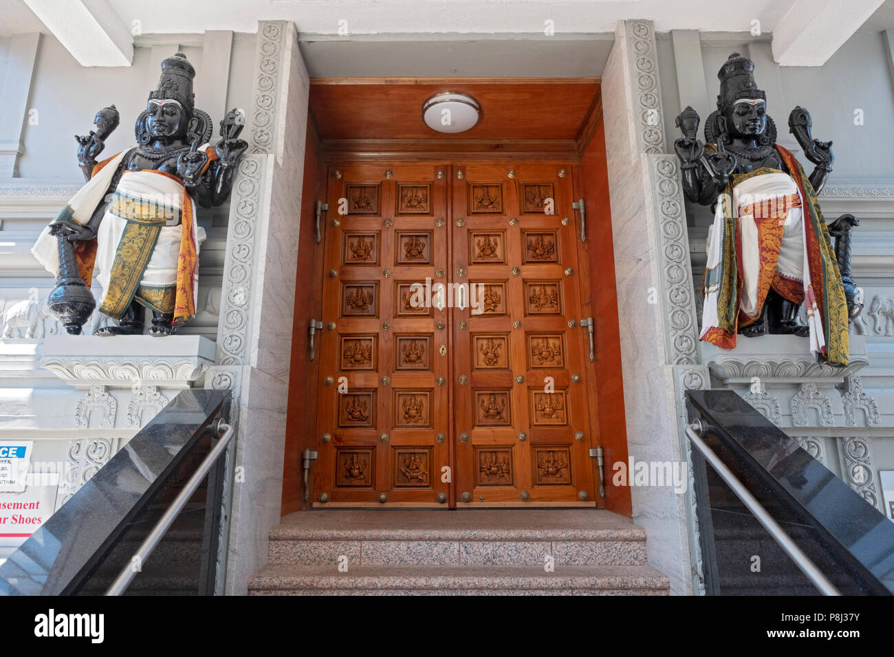 An ornate wooden door and statues at an entrance to the Hindu Temple Society in Flushing, Queens, New York City. Stock Photo
